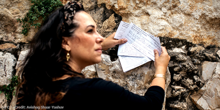 Yael Eckstein holding prayers written to The Fellowship as she's at The Western Wall.