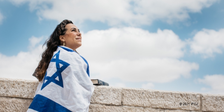 Yael Eckstein with Israeli flag and Bible, showing hope for International Holocaust Remembrance Day