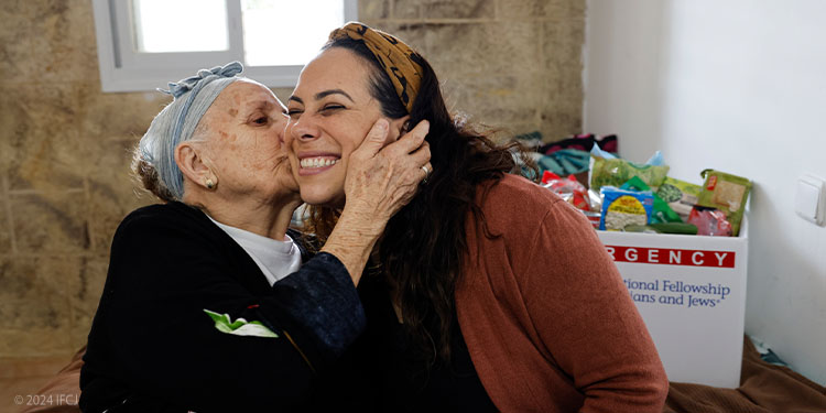 Yael kissed on the cheek by elderly woman