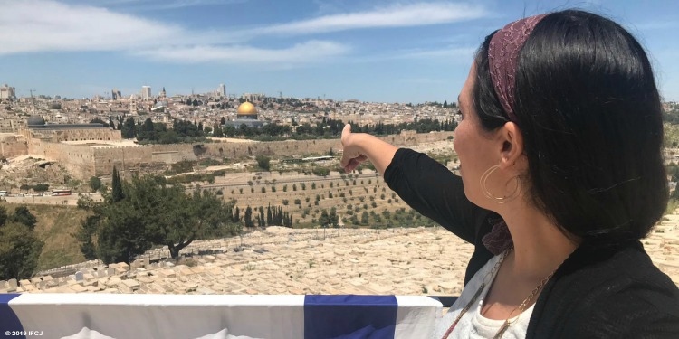 Yael Eckstein pointing at a temple with a gold top in Israel.
