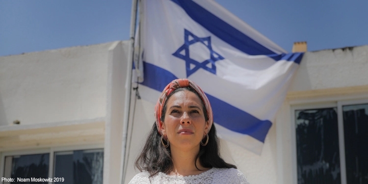 Yael standing in front of the Jewish flag
