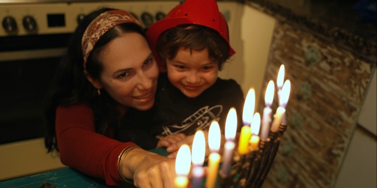 Yael and son light menorah