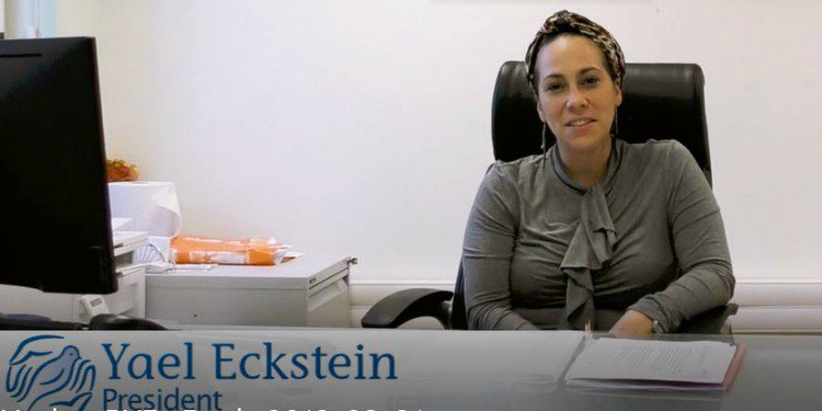 Yael Eckstein looking into the camera while sitting at a desk.