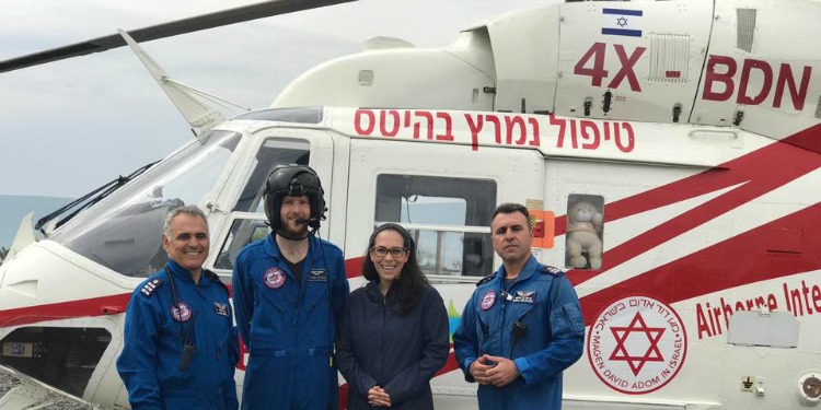 Yael Eckstein standing in front of a helicopter with three other people.