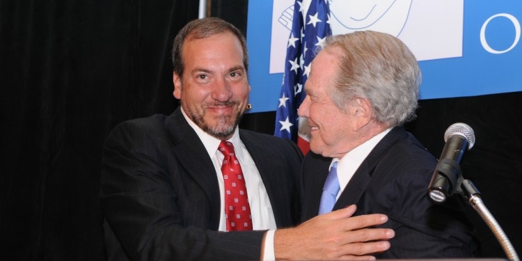 Rabbi Eckstein and 700 Club founder Pat Robertson smile and embrace each other in a hug