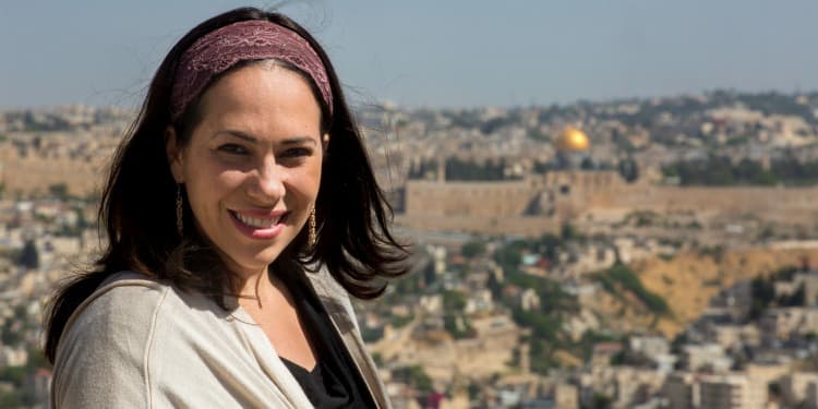 Yael Eckstein smiling into the camera while Jerusalem is behind her.