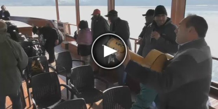 Screenshot of several church members on a boat as Rabbi Eckstein is singing and playing a guitar.
