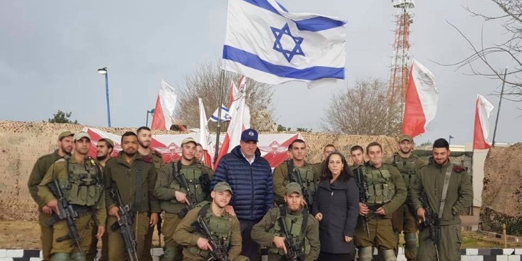 Soldiers posed with the Eckstein's in front of the Israeli flag.