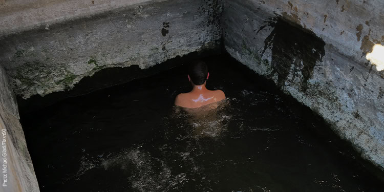 Young Israeli man bathes in a ritual bath