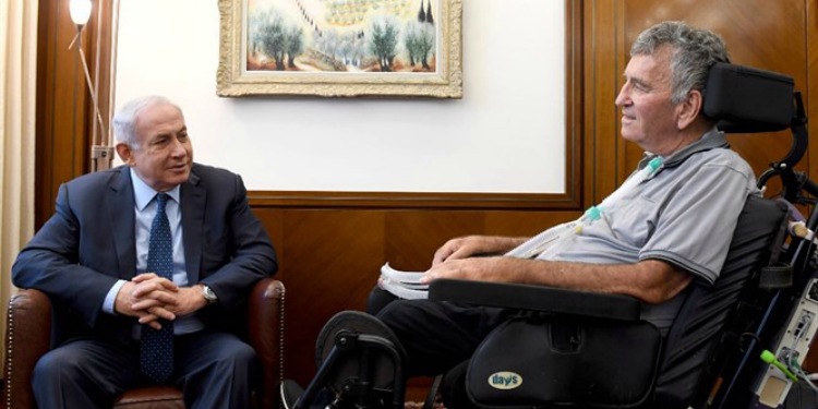 Bibi talking with a man who's in a wheelchair.