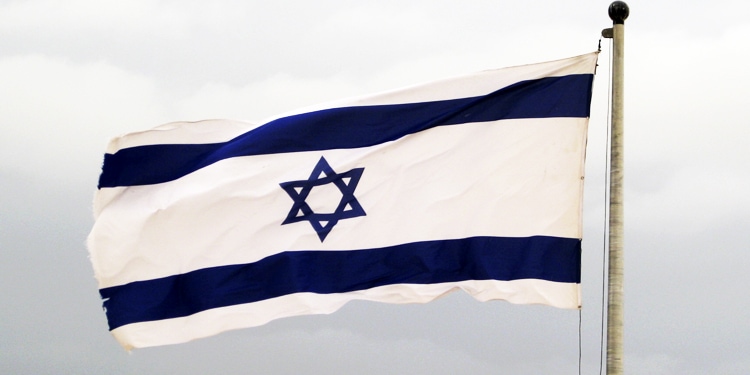 The Israeli flag flying in the air.