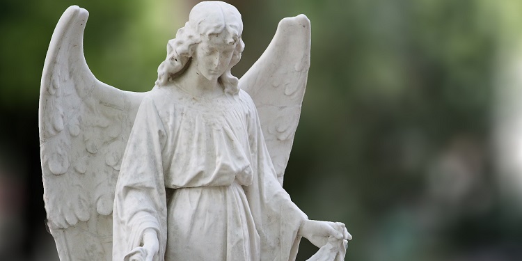 Statue of an angel with a green background.