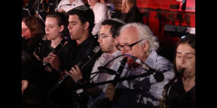 Several people playing instruments together at the Mashiv Haruach concert.