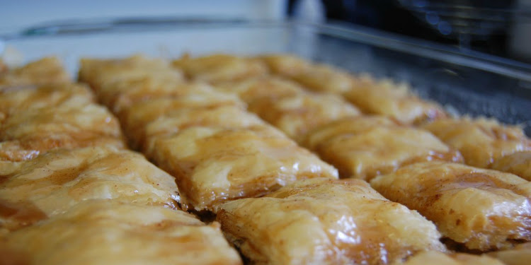 Close up image of baklava on a baking pan.