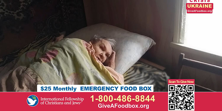 Elderly woman lying in bed, covered with a blanket, resting peacefully in a warm, simple home setting.