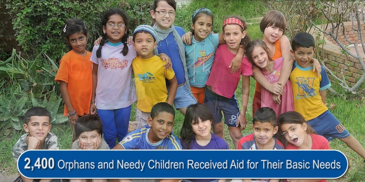 Several children standing outside among greenery smiling.