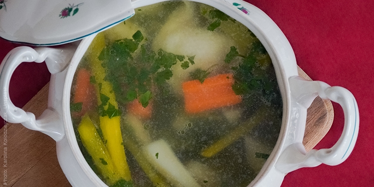 Close up image of soup with rice, broth, and carrots.