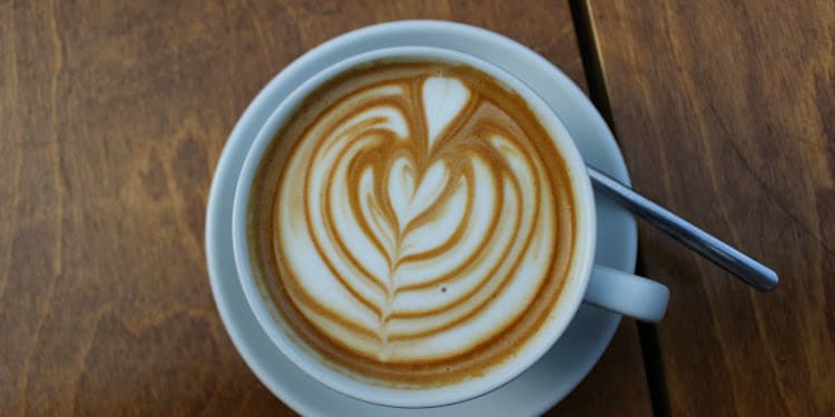 Coffee cup with cool design on a white plate.