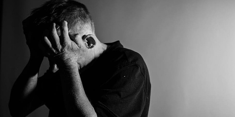 Man holding his hands up to head in anguish