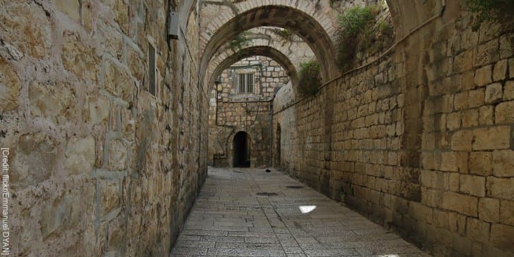 A concrete enclosed hallway with arches overhead.