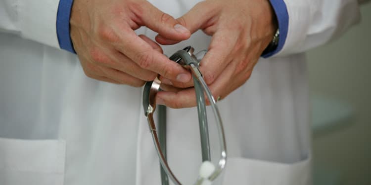 close up of a doctor's hands holding stethoscope