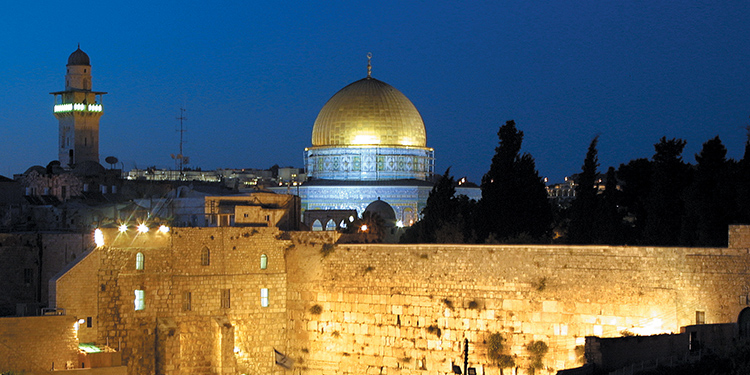 Dome of the Rock sitting just behind the Western Wall at nighttime.
