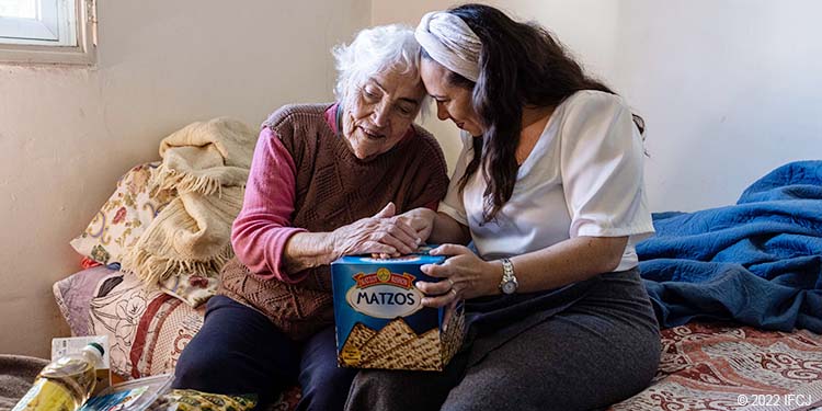 Elderly woman with Yael Eckstein holding matzah box