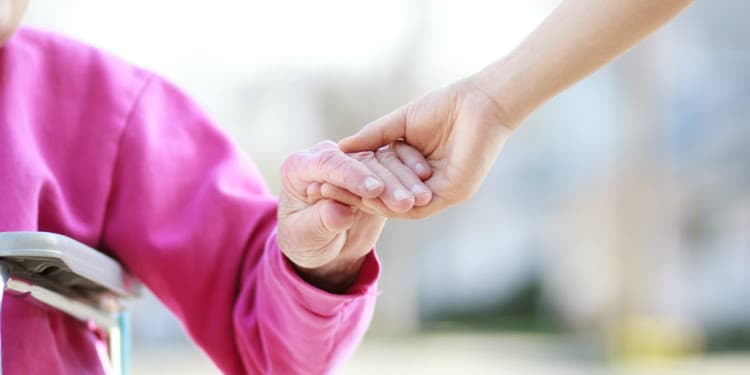 vulnerable elderly person holding hands with an Israel startup healthcare worker