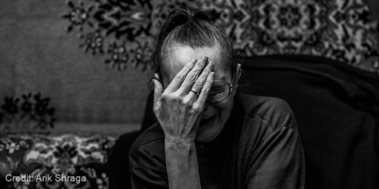 black and white, elderly woman, hand over face, crying