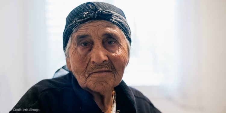 needy elderly woman in black shirt in Israel