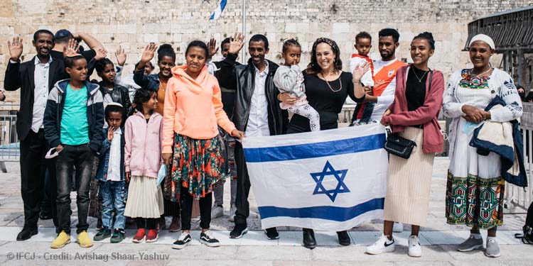Yael holding an Ethiopian child while next to Ethiopians at the Western Wall.