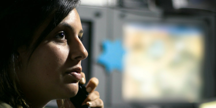 A woman talking on the phone while looking into the distance.