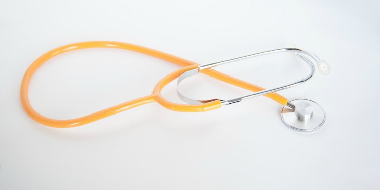 An orange stethoscope against a white background.
