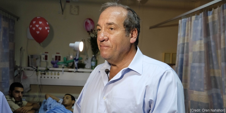 Rabbi Eckstein standing alongside a family in a hospital.