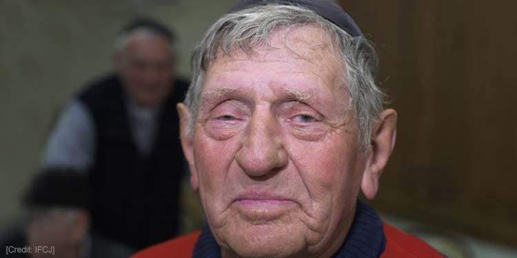 Elderly Jewish man looking straight ahead soft smiling.