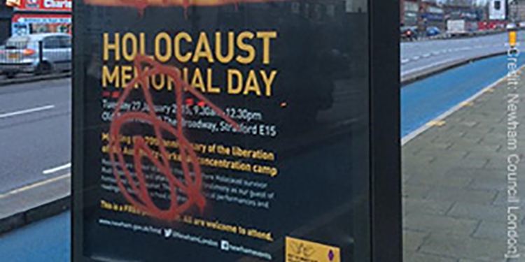 Graffiti stains a holocaust memorial poster