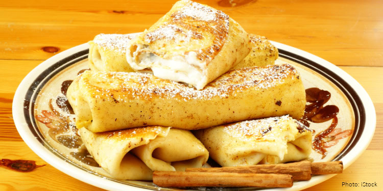 Delicious Shavuot pastries with cinnamon and powdered sugar, served on a decorative plate, representing traditional foods from around the world for the holiday.
