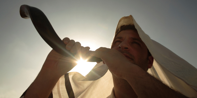 Man blowing shofar for when Yom Kippur begins