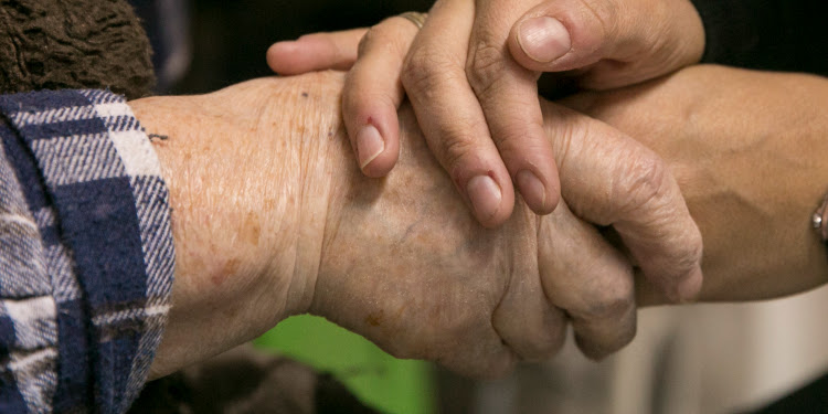 Close up image of two pairs of hands embracing each other.