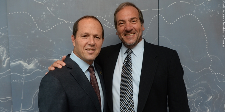 Rabbi Eckstein and Jerusalem's mayor smiling together with a black and white abstract background behind them.