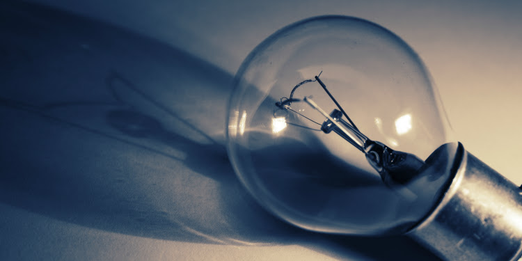 Close up image of a lightbulb with its shadow behind it.