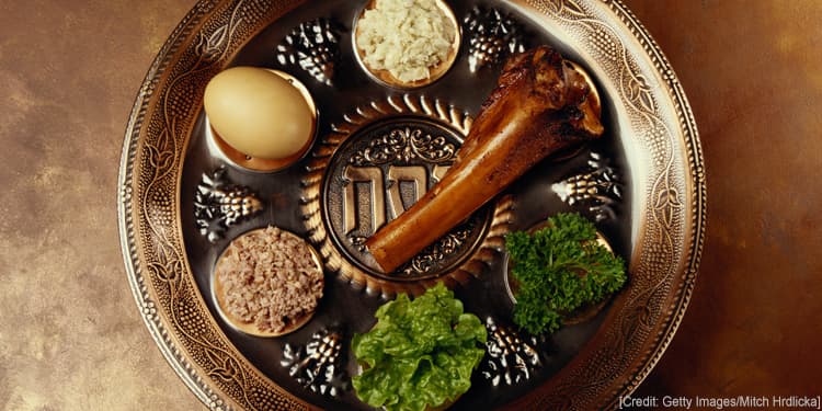 Seder plate with shank bone, egg, bitter herbs, and other food items.