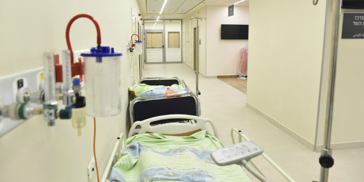 Medical hospital beds lined up in a hallway.