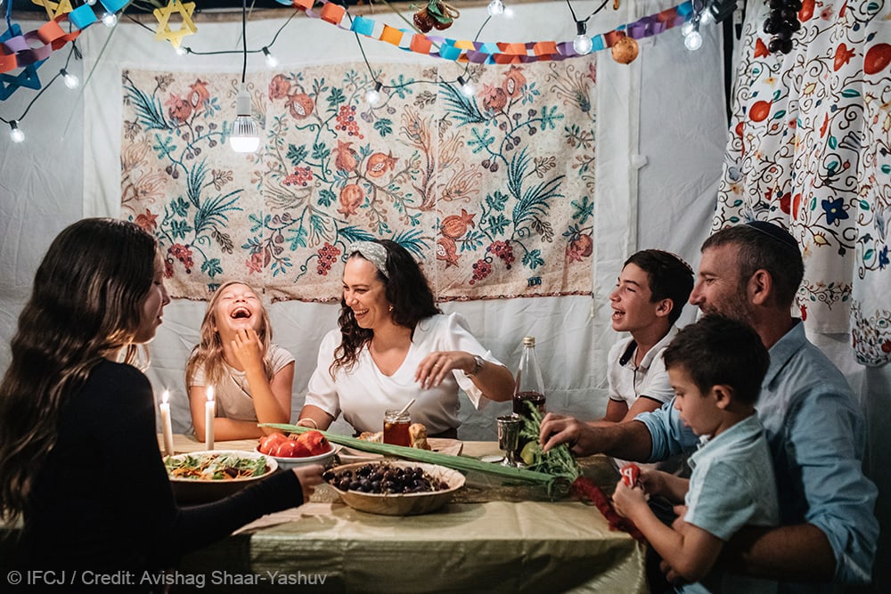 Yael sharing a meal with her family during Sukkot.