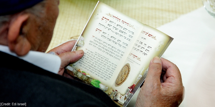 Aerial view of a Rabbi holding a book written in Jewish.