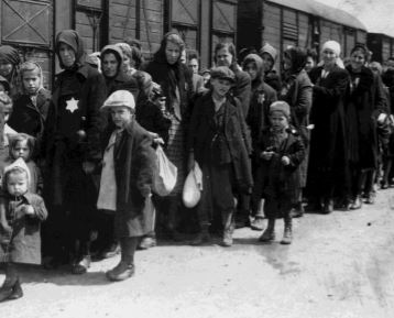 A black and white photo of Jews transported by train to Auschwitz