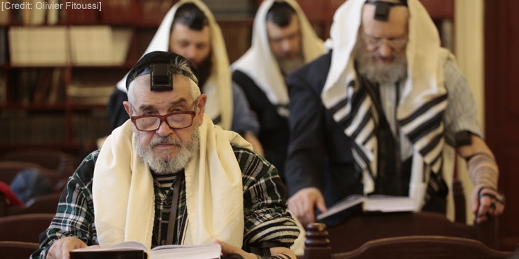 Several men reading scripture and praying together.