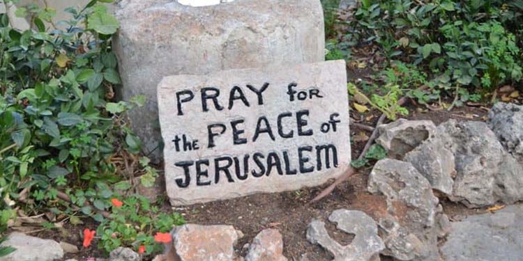 Stone with writting that reads Pray for the peace of Jerusalem