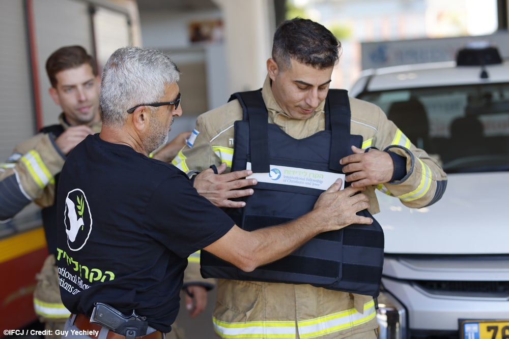 IFCJ staff distributing flak jackets to firefighters during the Israel Hamas war.