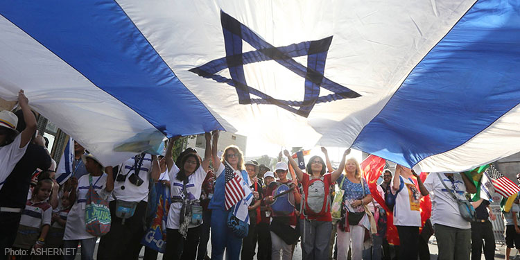 Group of people under stretched Israeli flag and star of david